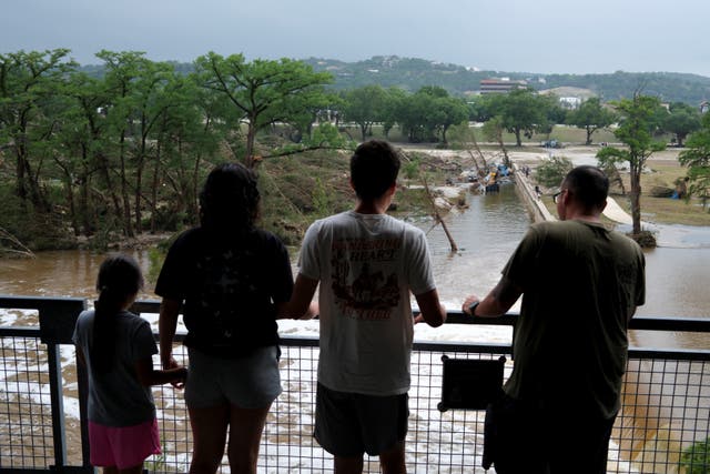 <p>Locals look on in horror at the devastation left by the flash flooding in Texas</p>