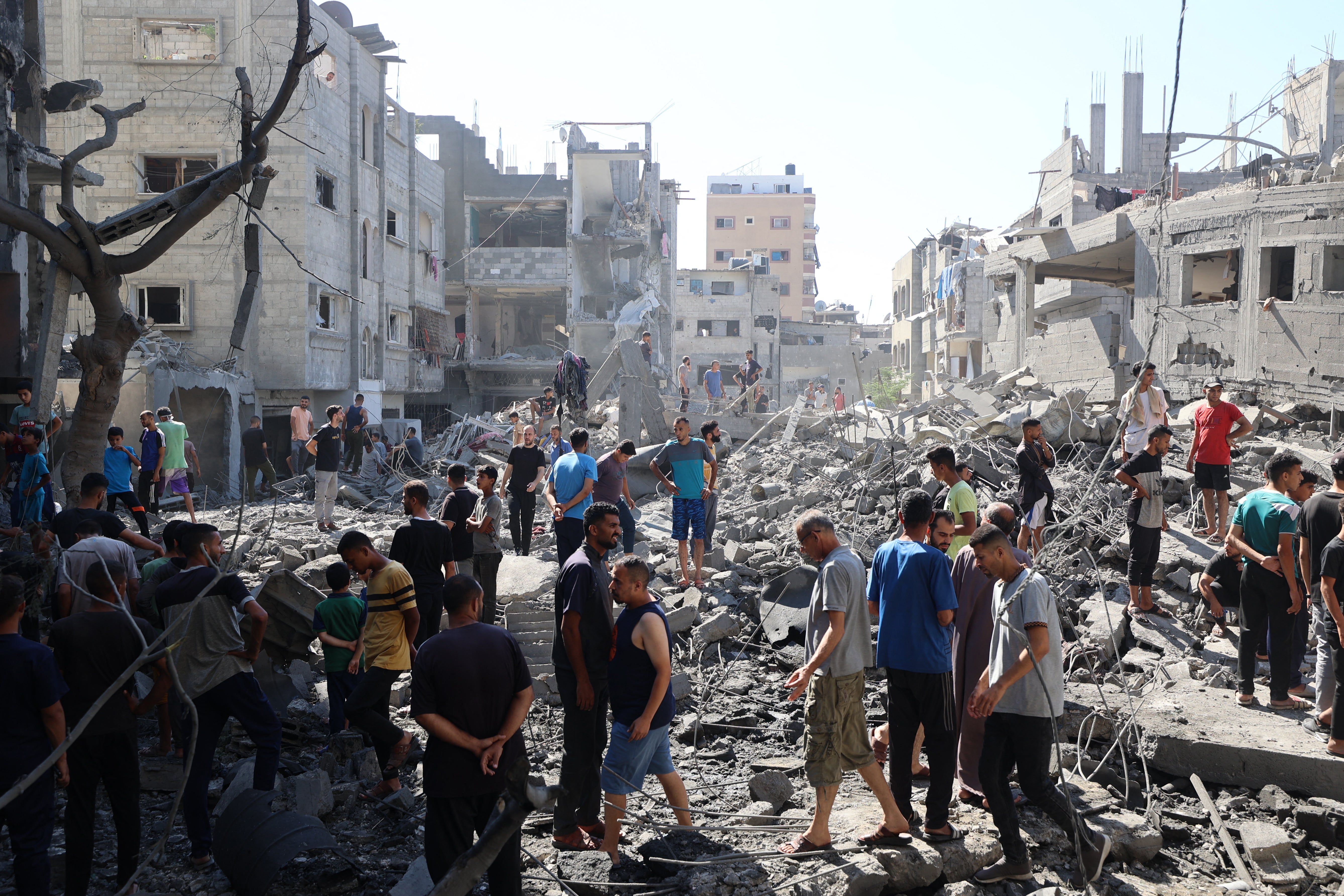 Palestinians inspect the damage after an Israeli strike in the Al-Bureij camp in the central Gaza Strip
