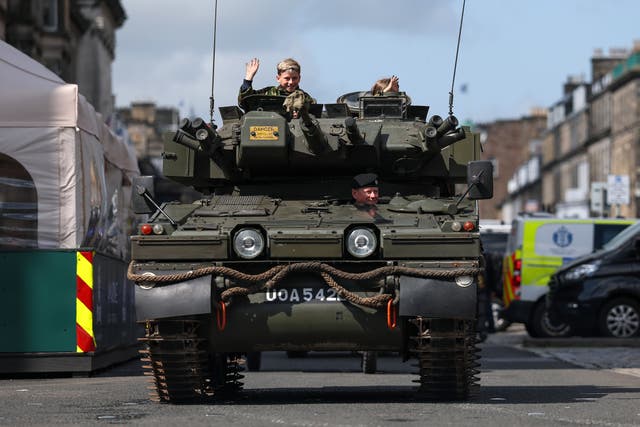 <p>A convoy of classic military vehicles drives along George Street as veterans take part in a parade in Edinburgh, Scotland</p>