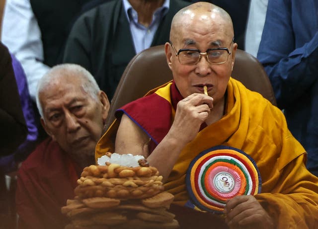 <p>Tibetan spiritual leader the Dalai Lama (R) eats snacks during a prayer ceremony celebrating his 90th birthday at the Main Tibetan Temple in McLeod Ganj, near Dharamshala, on 6 July, 2025</p>