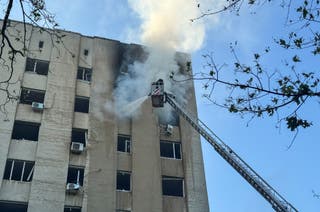 A firefighter works at the site of the building hit by a Russian drone strike in Kharkiv