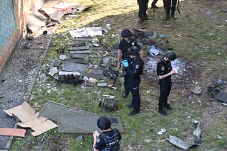Police officers examine the debris resulting from a Russian drone strike in Kharkiv