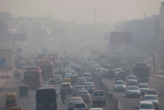<p>Indian commuters drive amidst heavy smog along a busy road past the South Extension area of New Delhi </p>