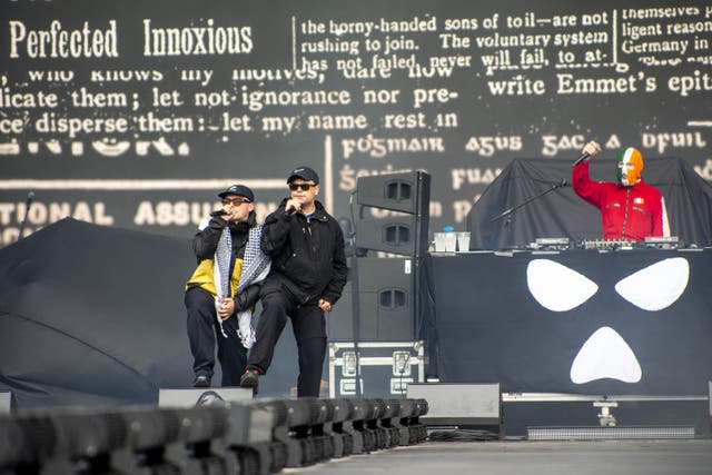 Liam Og O Hannaidh (Mo Chara) wearing a keffiyeh, Naoise O Caireallain (Moglai Bap), and JJ O’Dochartaigh (DJ Provai) from Kneecap performing on stage at London’s Finsbury Park (Jeff Moore/PA)