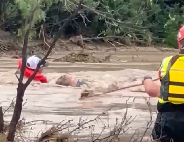 <p>Residents cling to rope as Texas floodwater surrounds them</p>
