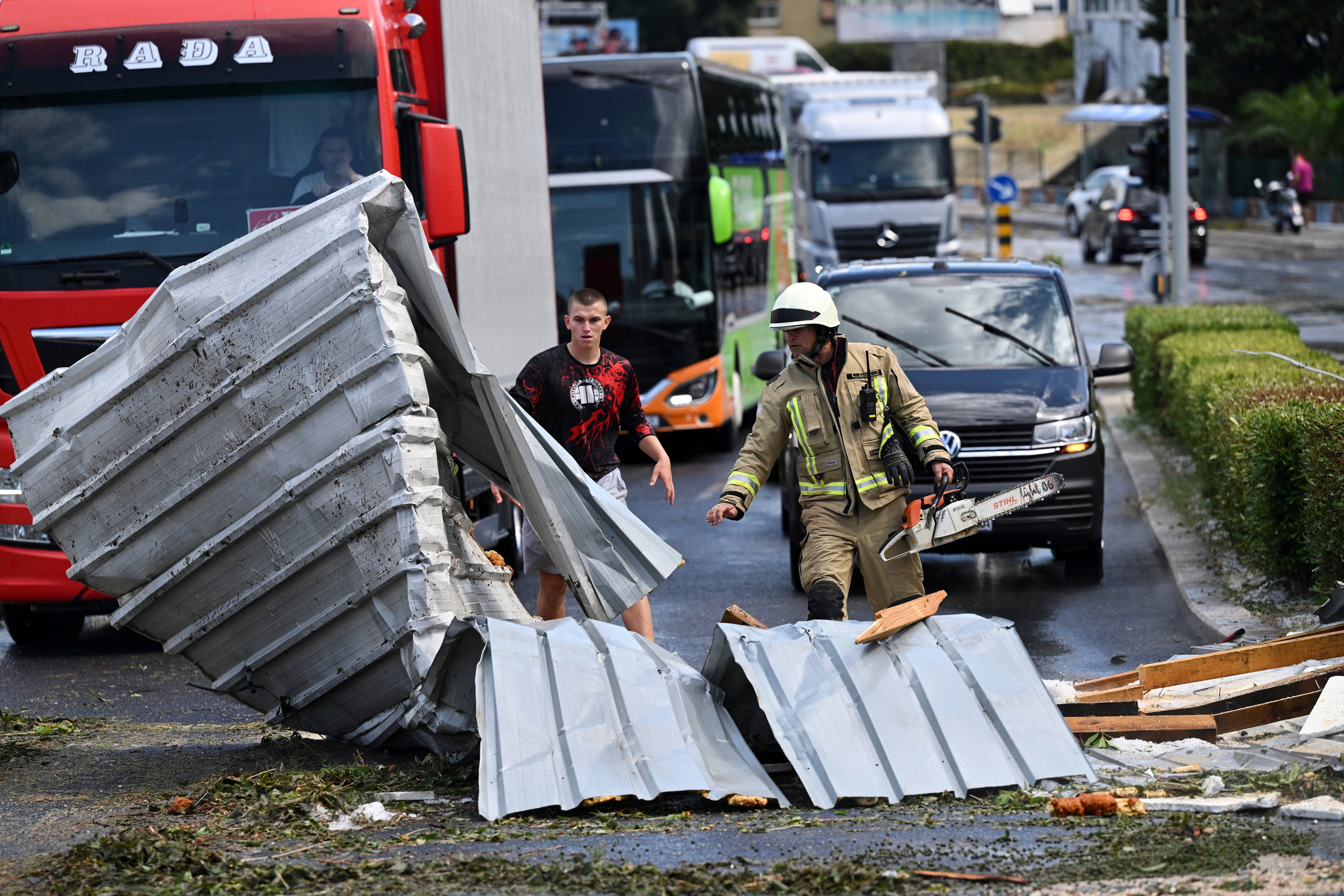 The firefighter removes debris from the street in Split, Croatia, Tuesday, 8. July 2025, after a strong storm. (AP Photo / Tom Dubravec)