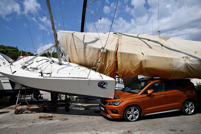 <p>A car and boats are damaged in Split, Croatia, Tuesday, July 8, 2025, following a powerful storm. (AP Photo/Tom Dubravec)</p>