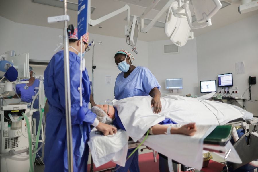 Breast cancer surgeon Aicha N'Doye, right, sings to soothe a patient during anesthesia prior to surgery in the operating room of the Bordeaux Nord polyclinic, France
