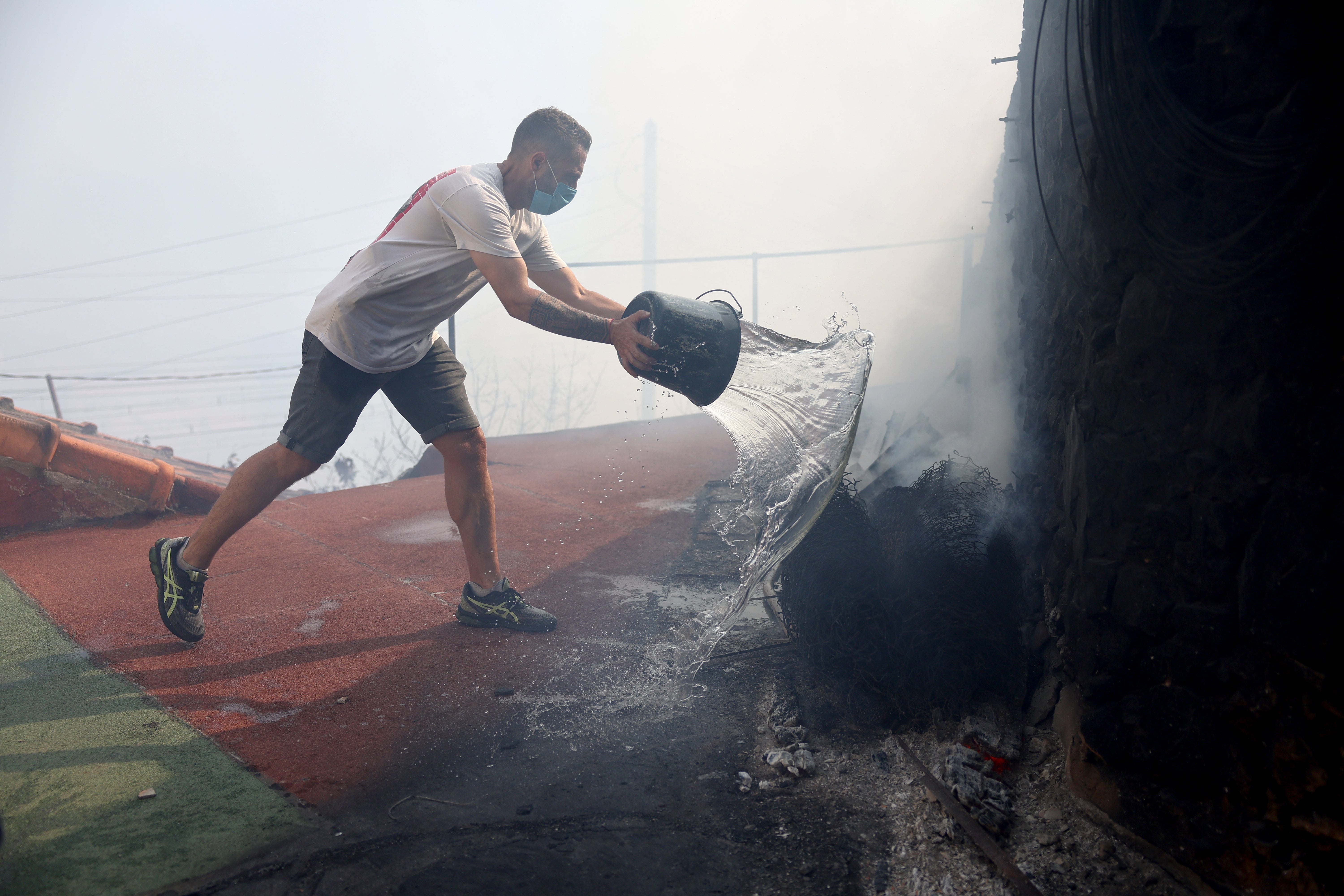The local resident attempts to take a fire to the wall during the wild fire