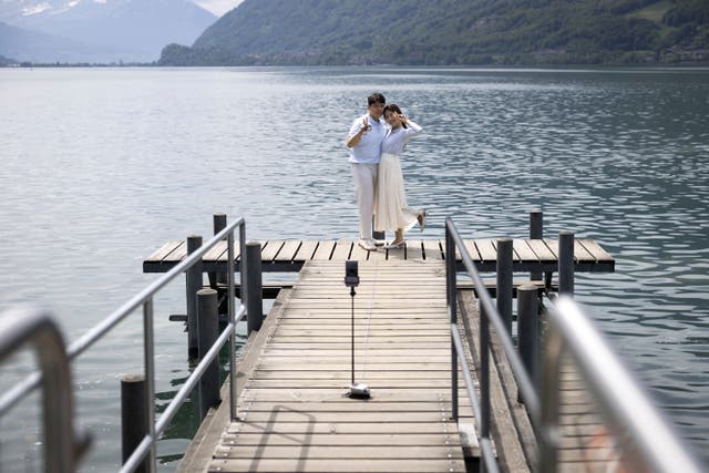<p>Korean visitors take pictures on the pier at Lake Brienz in Iseltwald, Switzerland, Sunday, May 21, 2023</p>