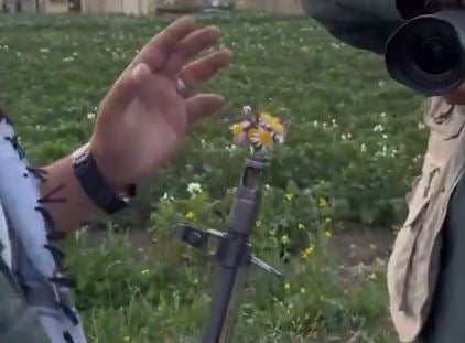 در یکی از عکسهای نهایی ، یک گل به بشکه مسلسل منتقل می شود