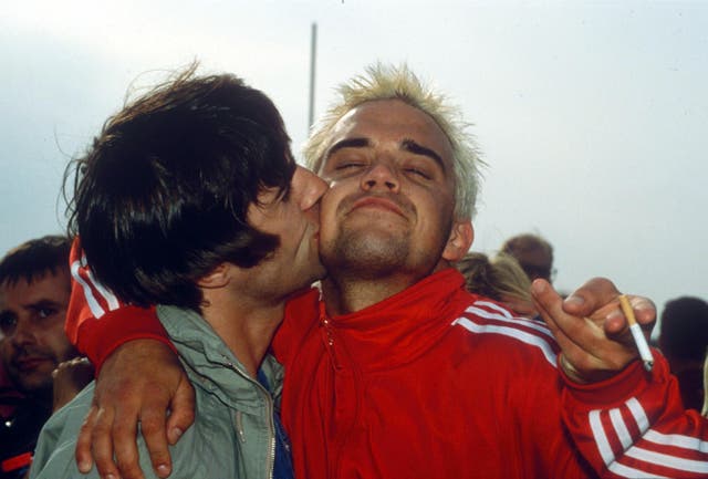 <p>Blondes have more fun: Liam Gallagher plants a smacker on Robbie Williams during the 1995 Glastonbury Festival</p>