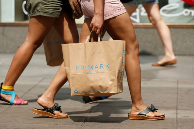 General view of shopper with Primark bag on Oxford Street, London during warm summer weather.