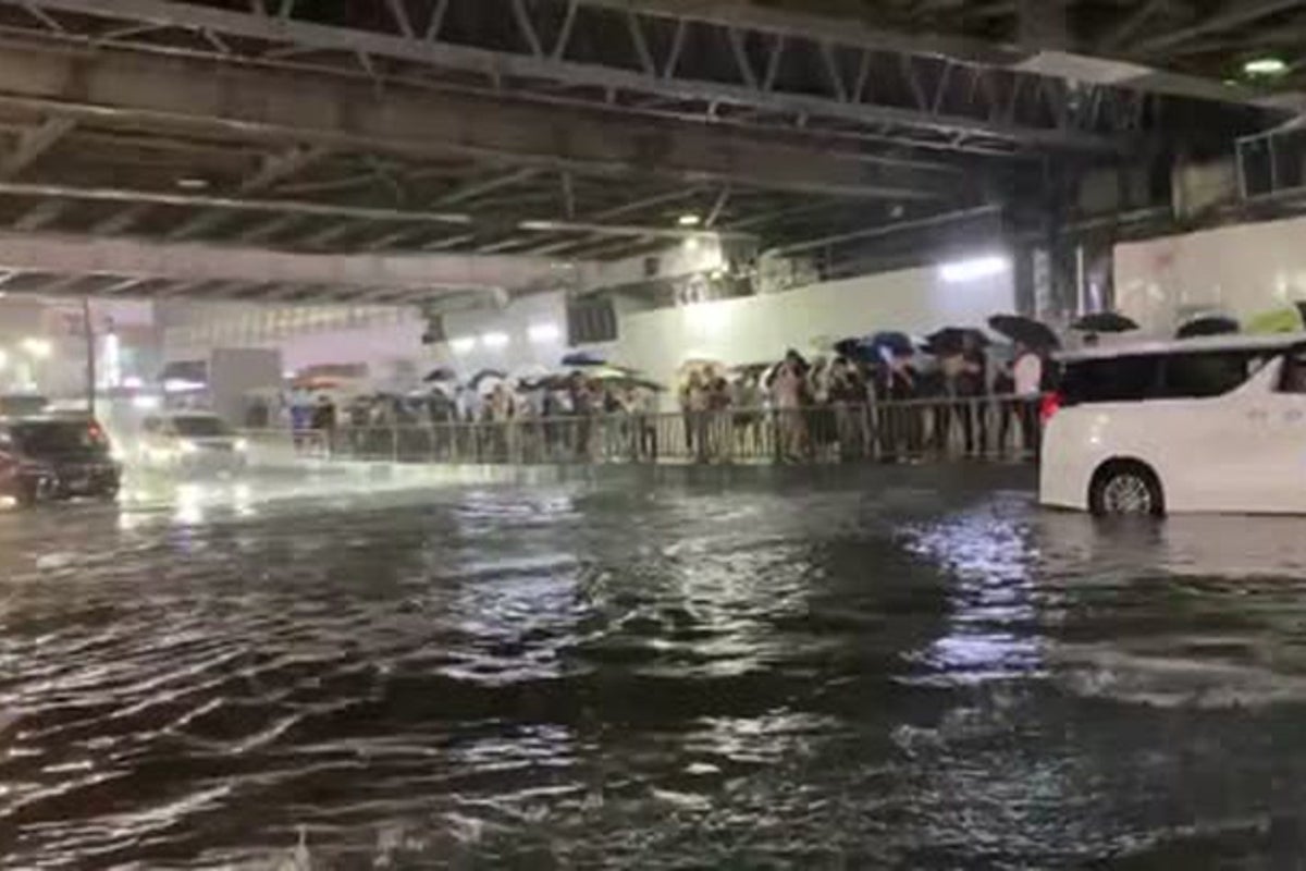 Tokyo road submerged in water as record rainfall causes flooding