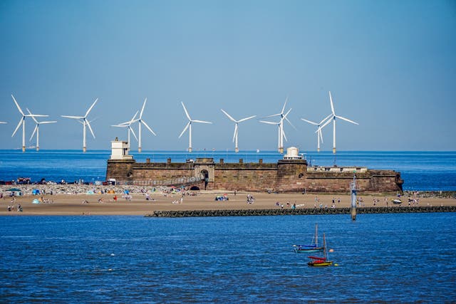 People on the beach at New Brighton on the River Mersey, as the third heatwave of the summer hits the UK (Peter Byrne/PA)