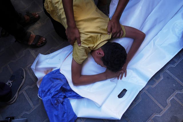 <p>A Palestinian boy mourns over the body of his 12-year-old friend, Abdullah Ahmed, who was killed in an Israeli strike that targeted a drinking water distribution point</p>