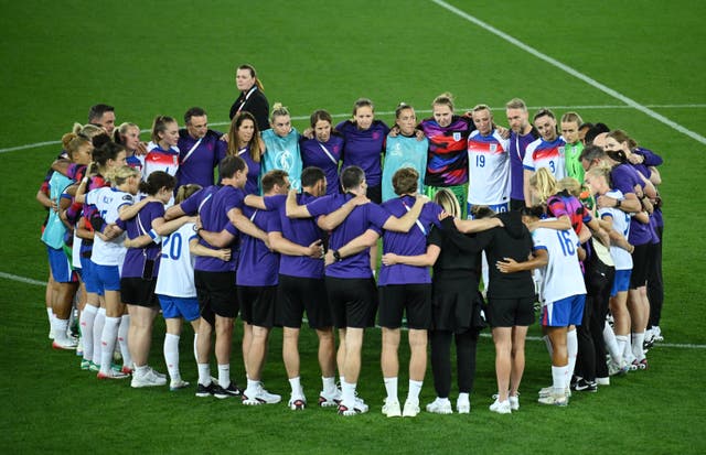 <p>England players and staff form a huddle on the pitch after the match</p>