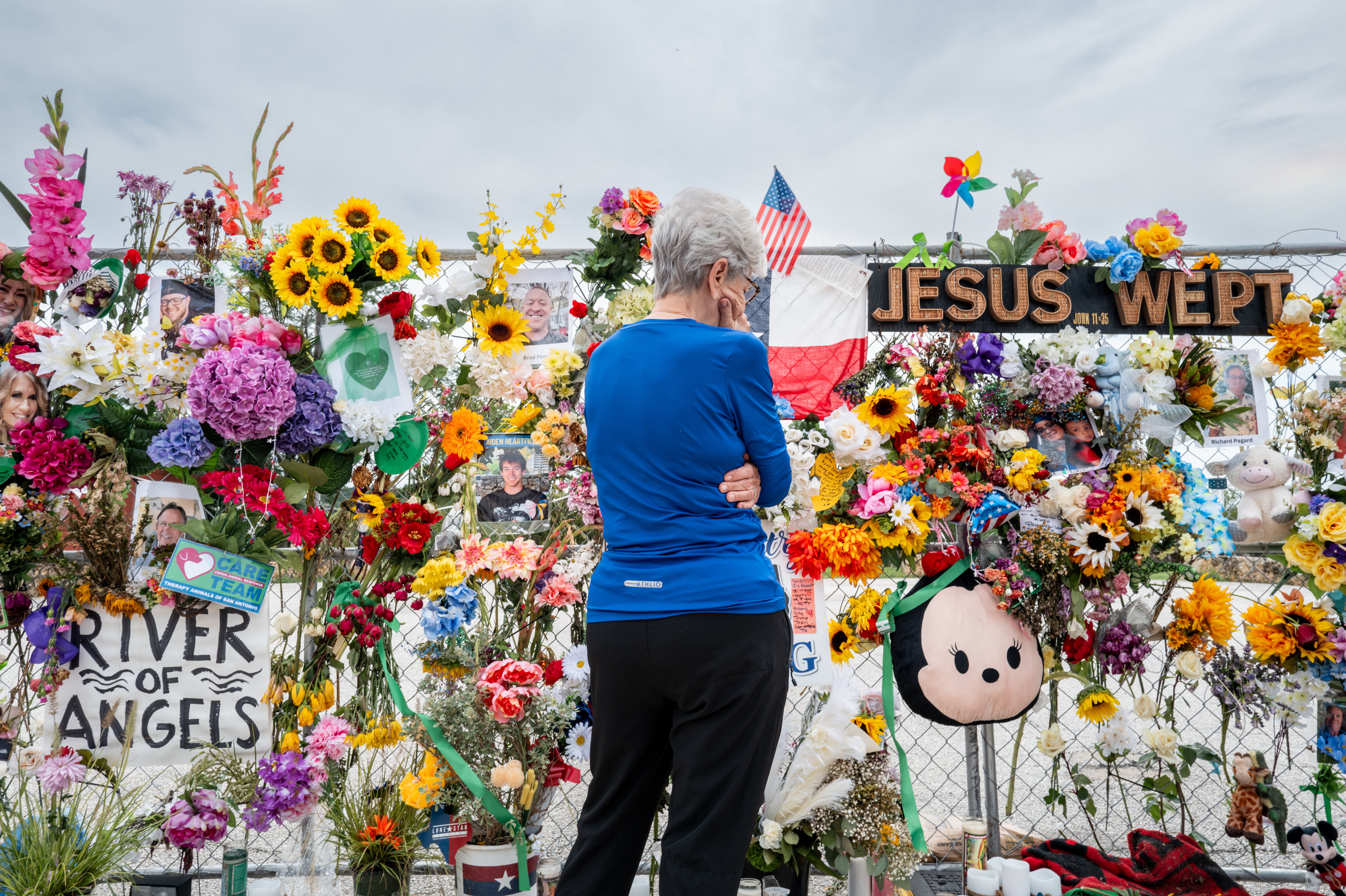 A person stands in front of a memorial wall for the Texas flood victims on Sunday. At least 132 people have died as of Monday morning