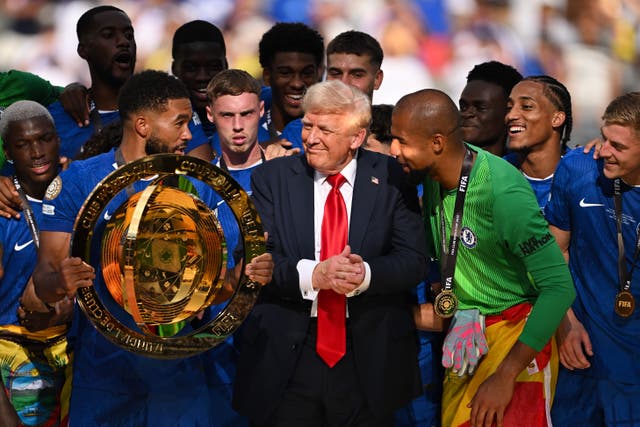 <p>Reece James, holding the trophy, hesitates as Donald Trump lingers for Chelsea's big moment</p>