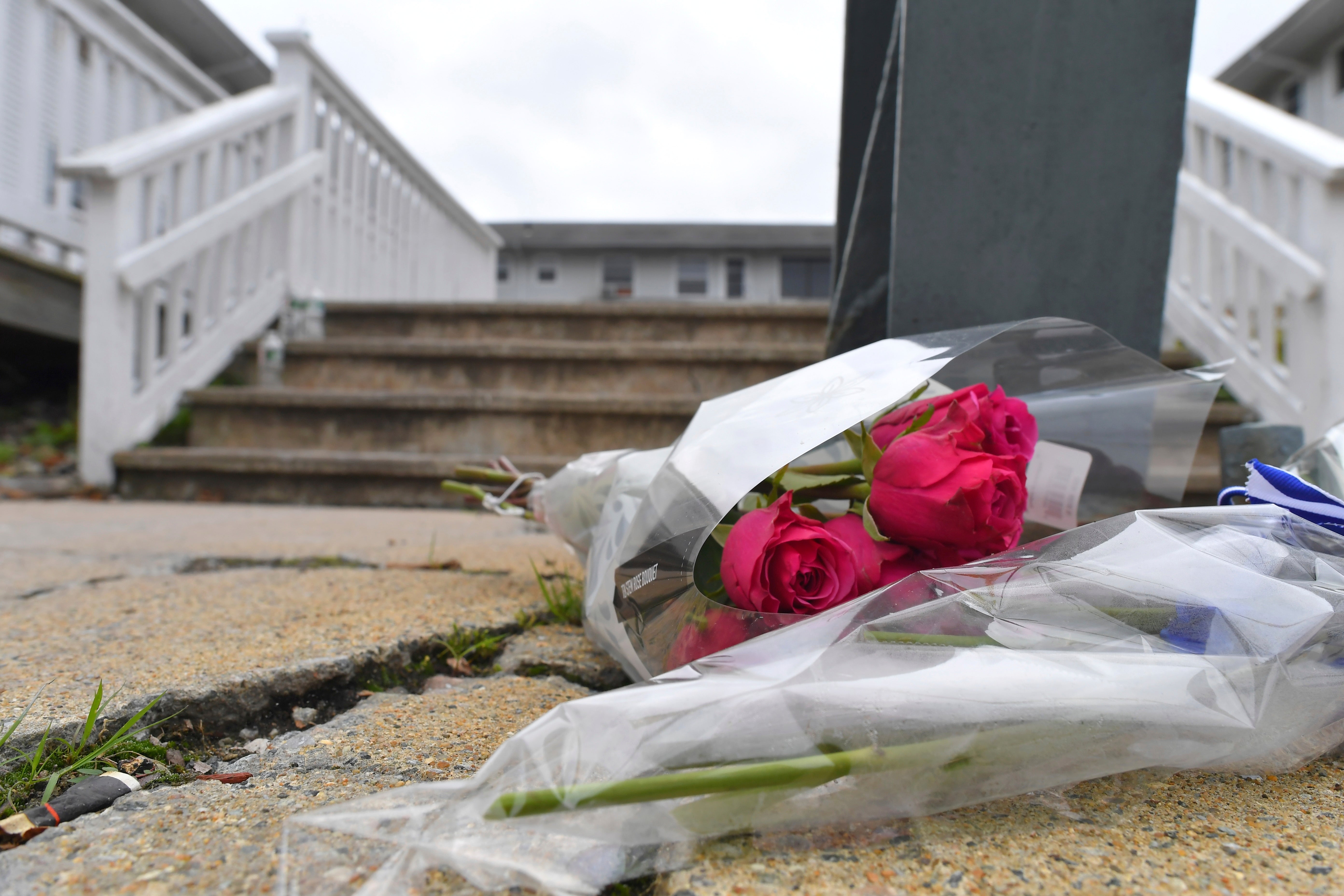 Flowers rest outside the Gabriel House Assisted Living Facility on Monday to honor victims of the deadly fire. Investigators are still looking into the cause of the fire but say it does not appear to be suspicious