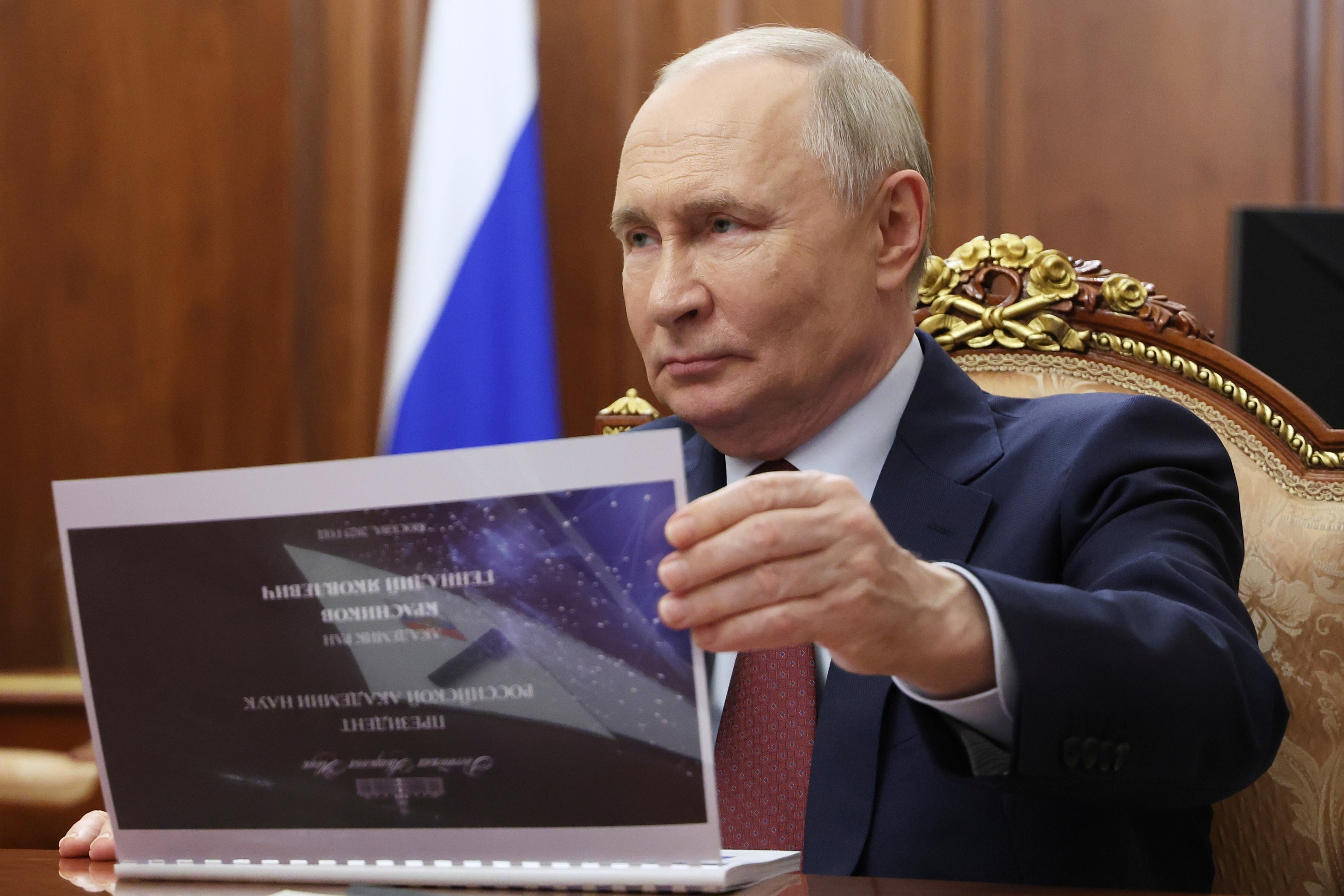 Russian President Vladimir Putin listens to Russian Academy of Sciences President Gennady Krasnikov during their meeting at the Kremlin in Moscow