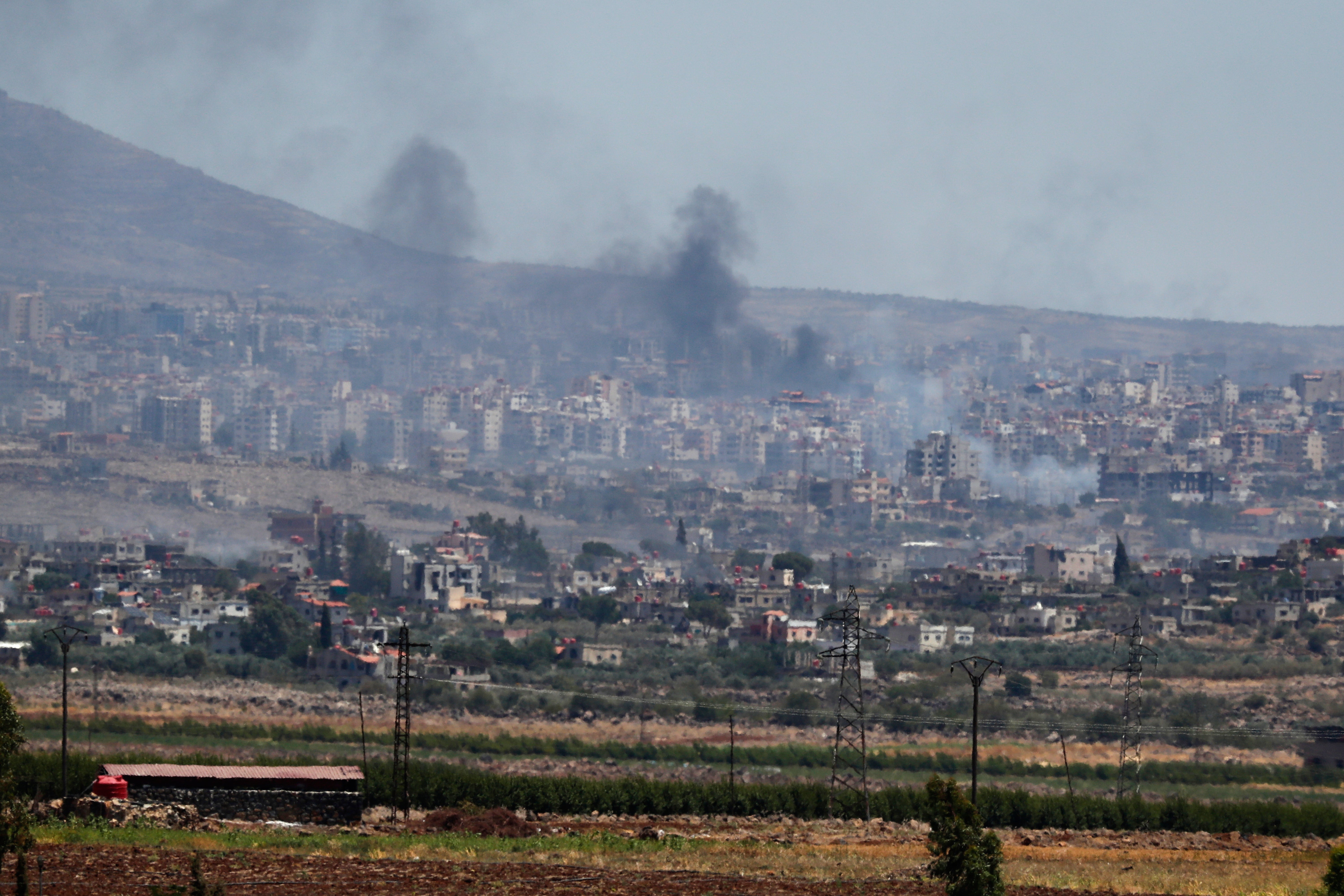 Smoke billows after clashes between Syrian government forces and Druze militias in southern Syria