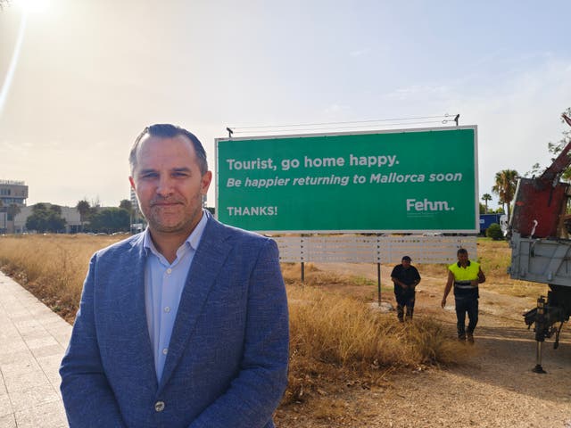<p>Javier Vich, president The Mallorca Hotel Business Federation, next to a new poster welcoming tourists to Mallorca</p>