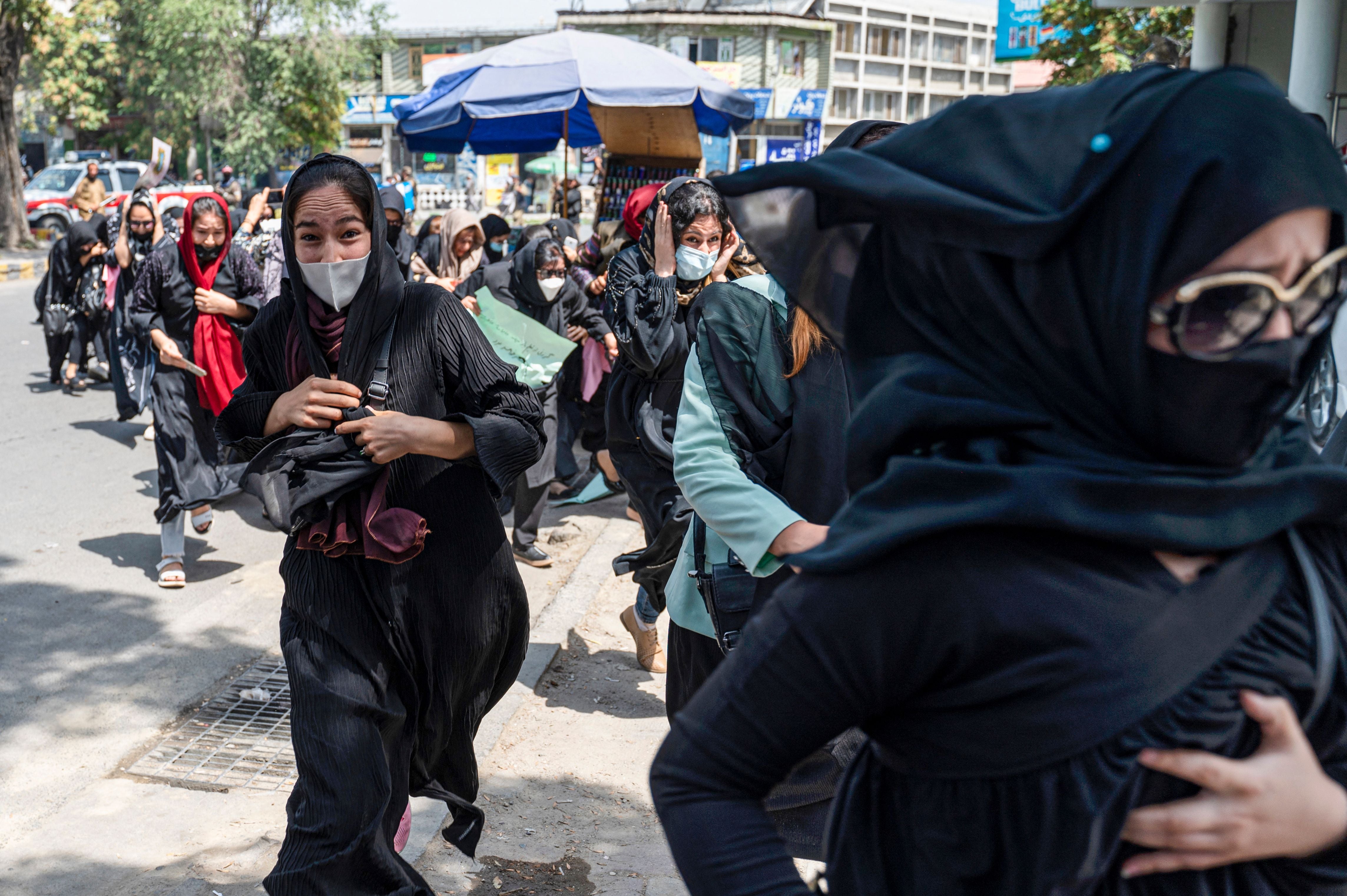 Taliban fighters fire into the air to disperse Afghan women protesters in Kabul on August 13, 2022.