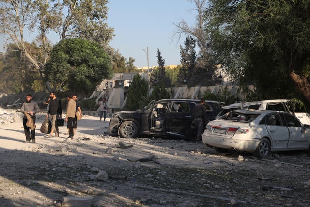 <p>Men leave the damaged Syrian defence ministry building in Damascus which was hit by several Israeli airstrikes</p>