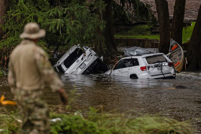 <p>Vehicles sit submerged as a search and rescue worker looks through debris for any survivors or remains of people in Hunt, Texas. The 1,000-year flood event was one of four that happened in just a week across the U.S.</p>