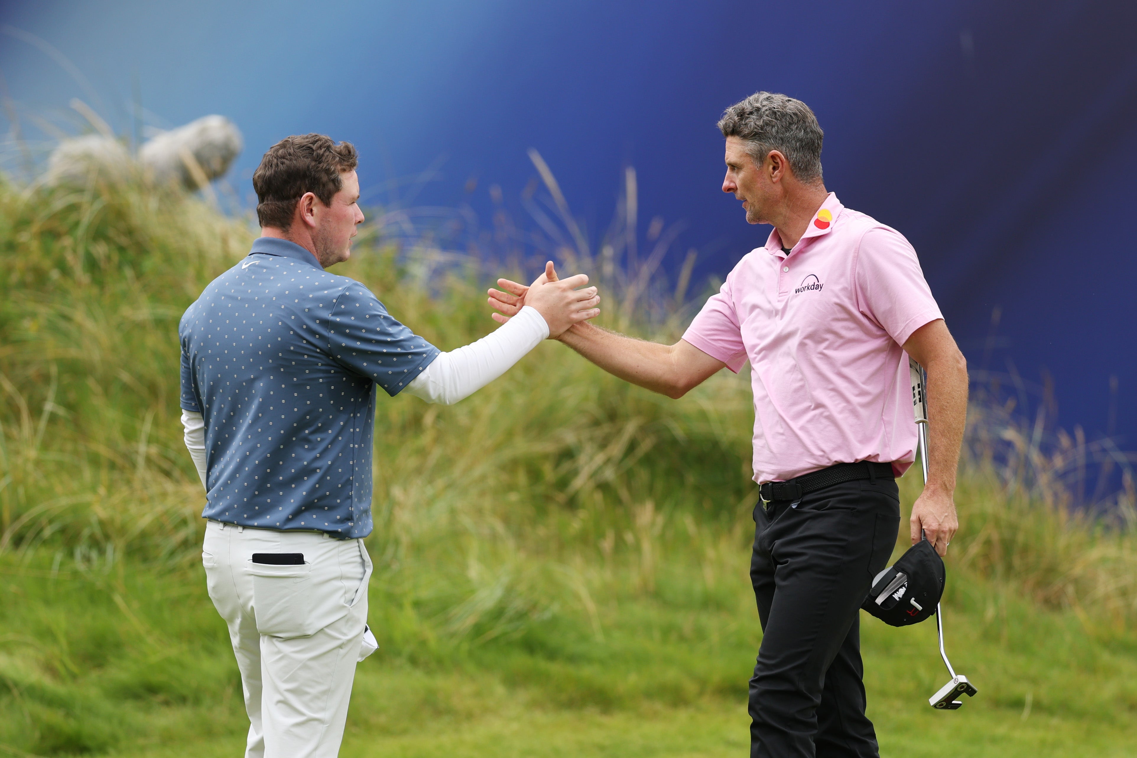 Justin Rose of England and Robert MacIntyre of Scotland shake hands after finishing their round