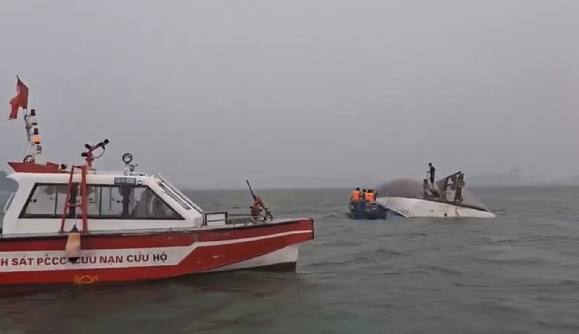 People are rescued from the capsized boat after it was knocked over during a sudden thunderstorm