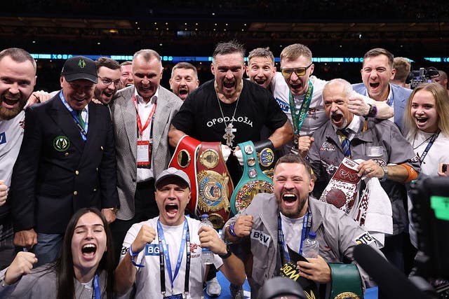 <p>Oleksandr Usyk poses for a photo with the title belts and members of his team after victory over Daniel Dubois </p>