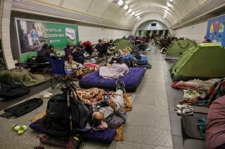 People take shelter inside a metro station during a Russian drone strike in Kyiv