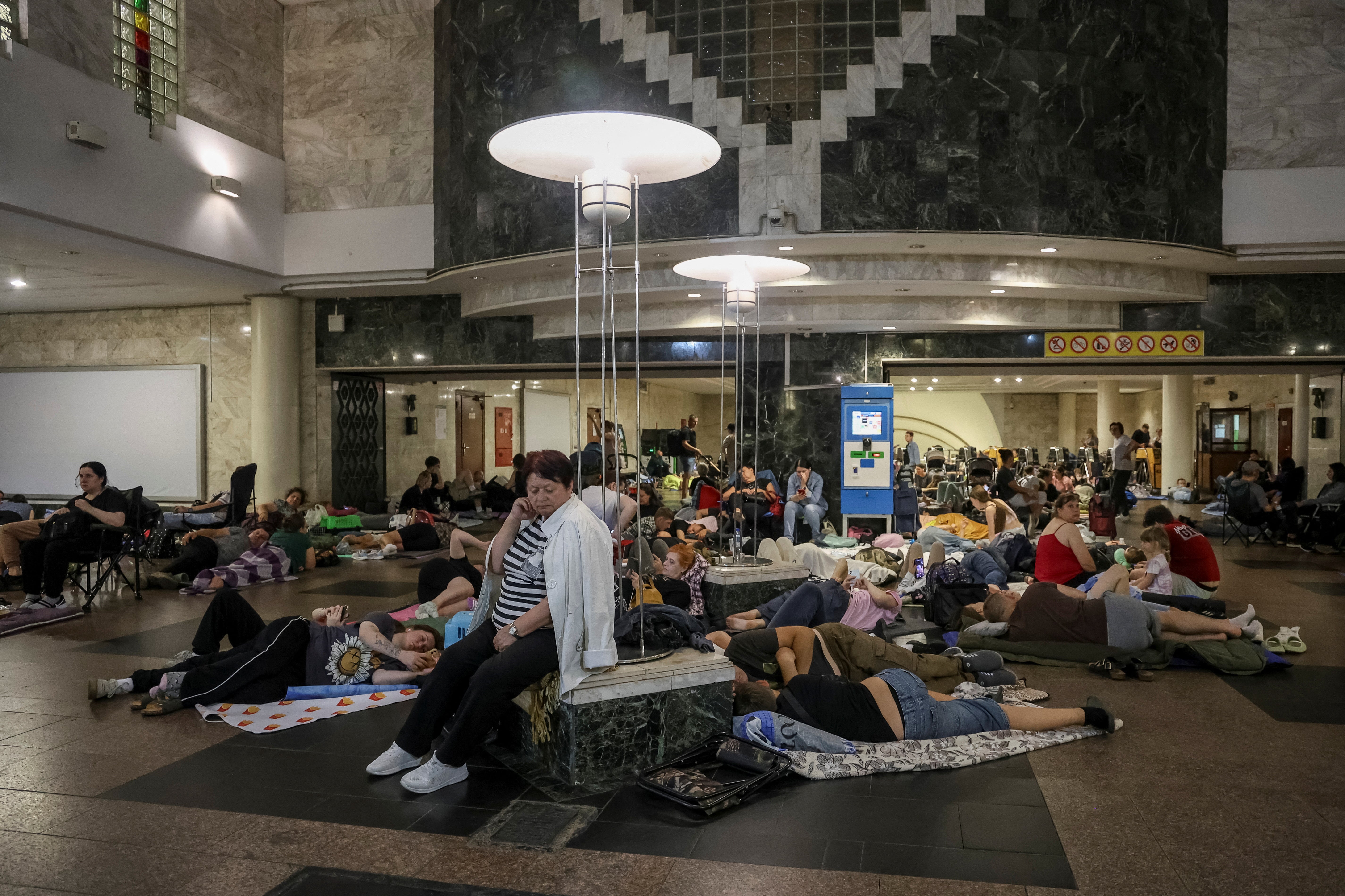 People take shelter inside a metro station during a Russian drone strike in Kyiv