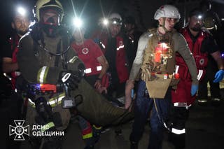 Rescuers and medical workers evacuate a resident from an apartment building damaged during a Russian drone strike, amid Russia's attack on Ukraine, in Odesa