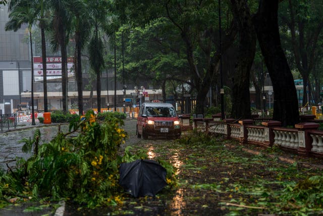 <p>A taxi drives near fallen trees following the Typhoon Wipha, in Hong Kong</p>