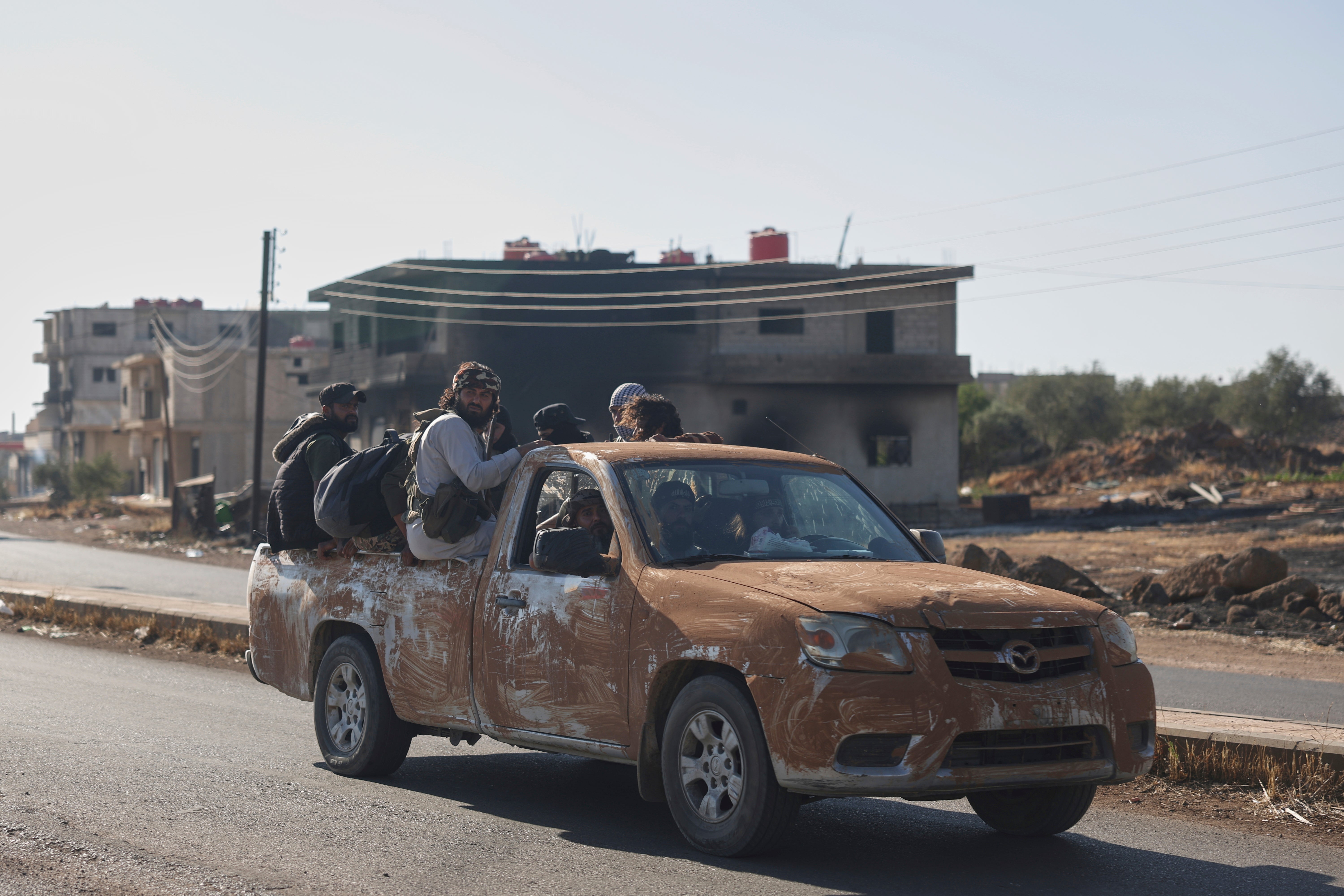 Bedouin fighters ride in a truck in Mazraa village on the outskirts of Sweida city in southern Syria on 19 July 2025