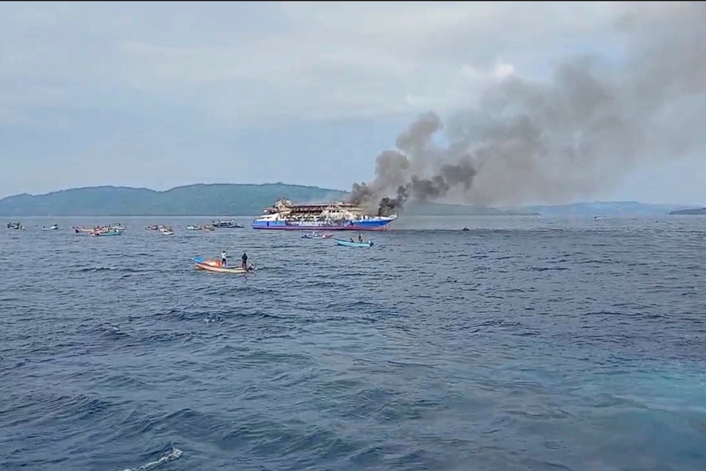 <p>Smoke billows from passenger ship KM Barcelona after it caught fire in the waters off Talise Island in North Sulawesi, Indonesia, Sunday, 20 July 2025</p>