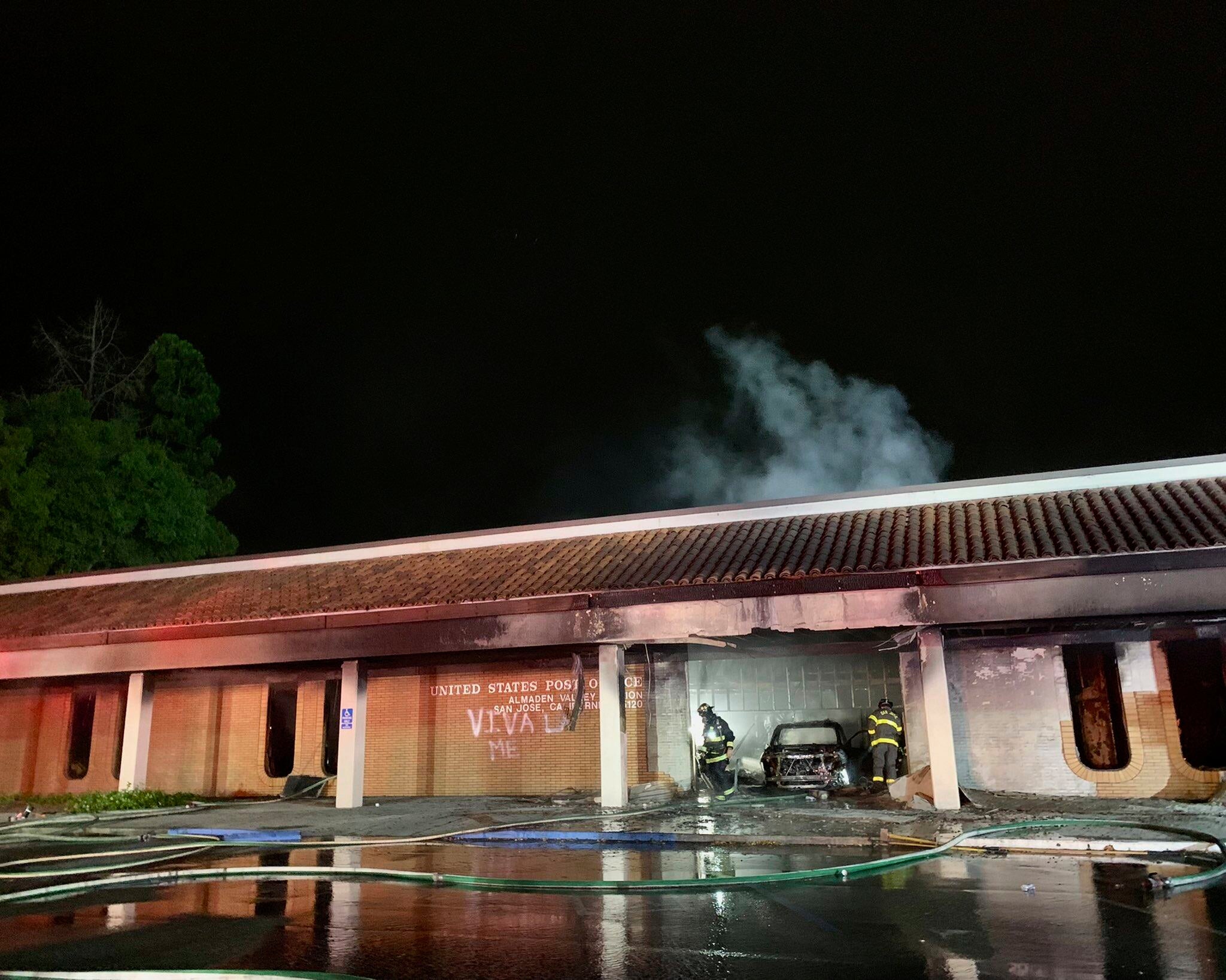 This photo provided by the San Jose Fire Department shows firefighters responding to a fire burning after a car crashed into the Post Office, early Sunday, July 20, 2025, in San Jose, California. Richard Tillman, the brother of NFL player and Army Ranger Pat Tillman, was arrested in connection to the crash