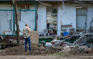 A man films in front of a damaged apartment building after the shelling in Donetsk, Russian-controlled Ukraine