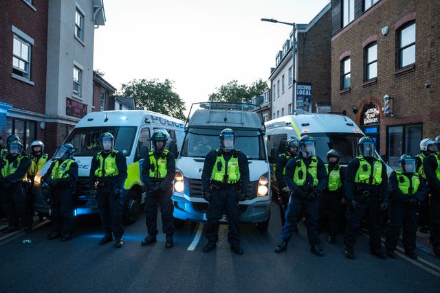 <p>Police officers in Epping, Essex, block a road during a demonstration near the Bell Hotel</p>