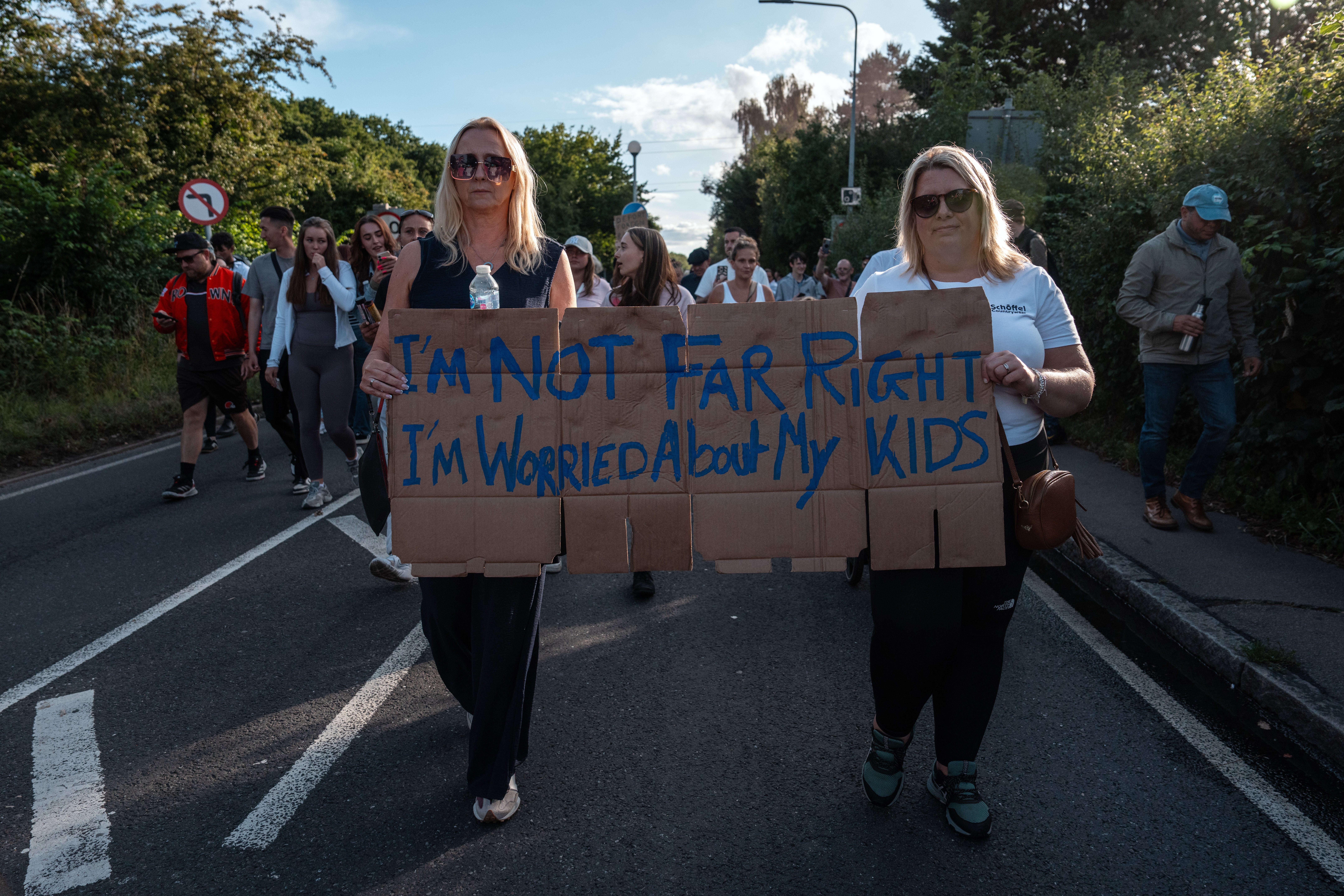 Women hold a placard while performing near Bell Hotel on Sunday 20 July.
