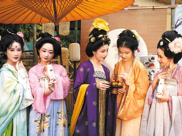 <p>Visitors dressed in Tang Dynasty costumes sample Adopt a Cow’s new dairy products in Hangzhou, Zhejiang province</p>