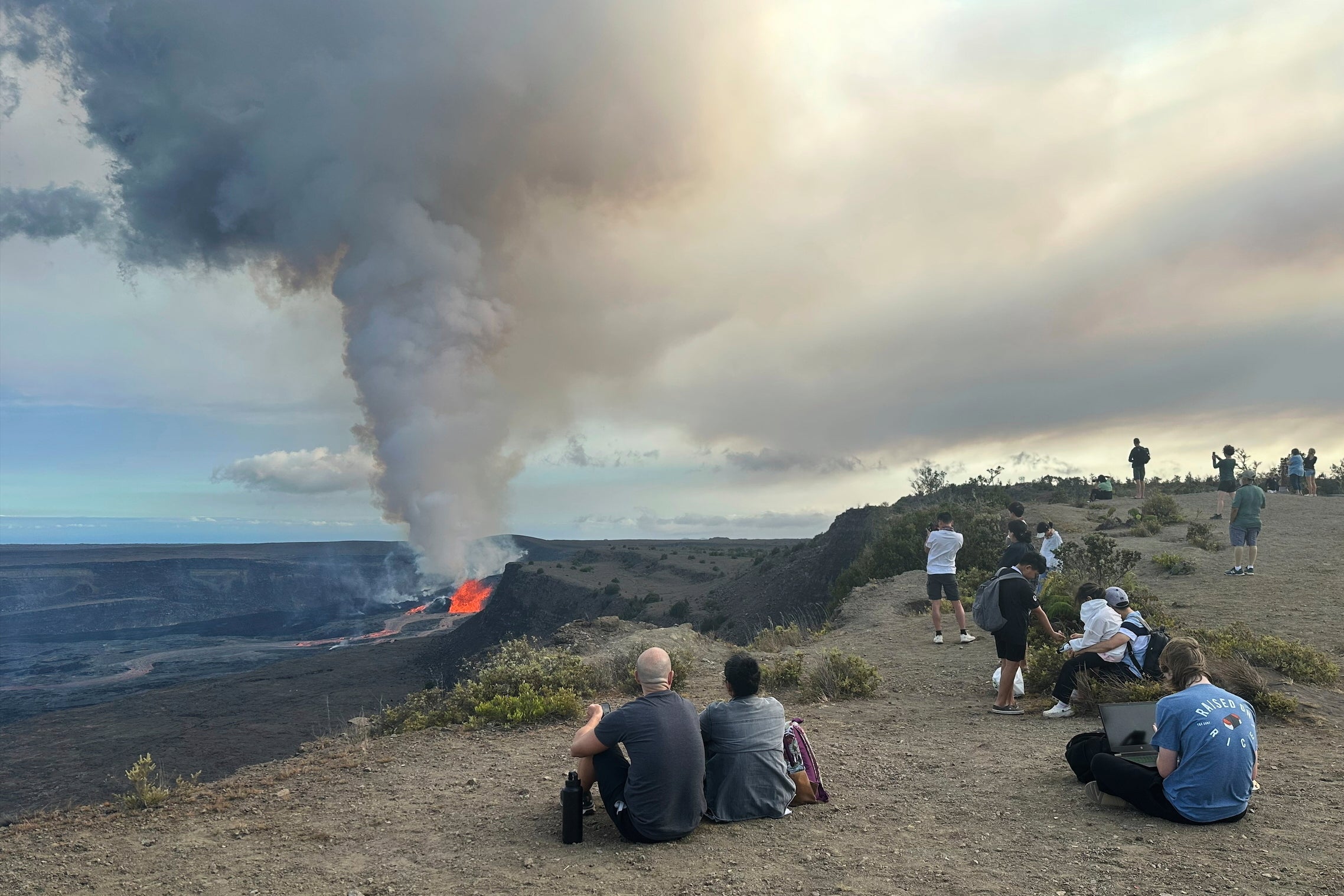 People watch the Kilauea volcano on Hawaii's Big Island as it erupts