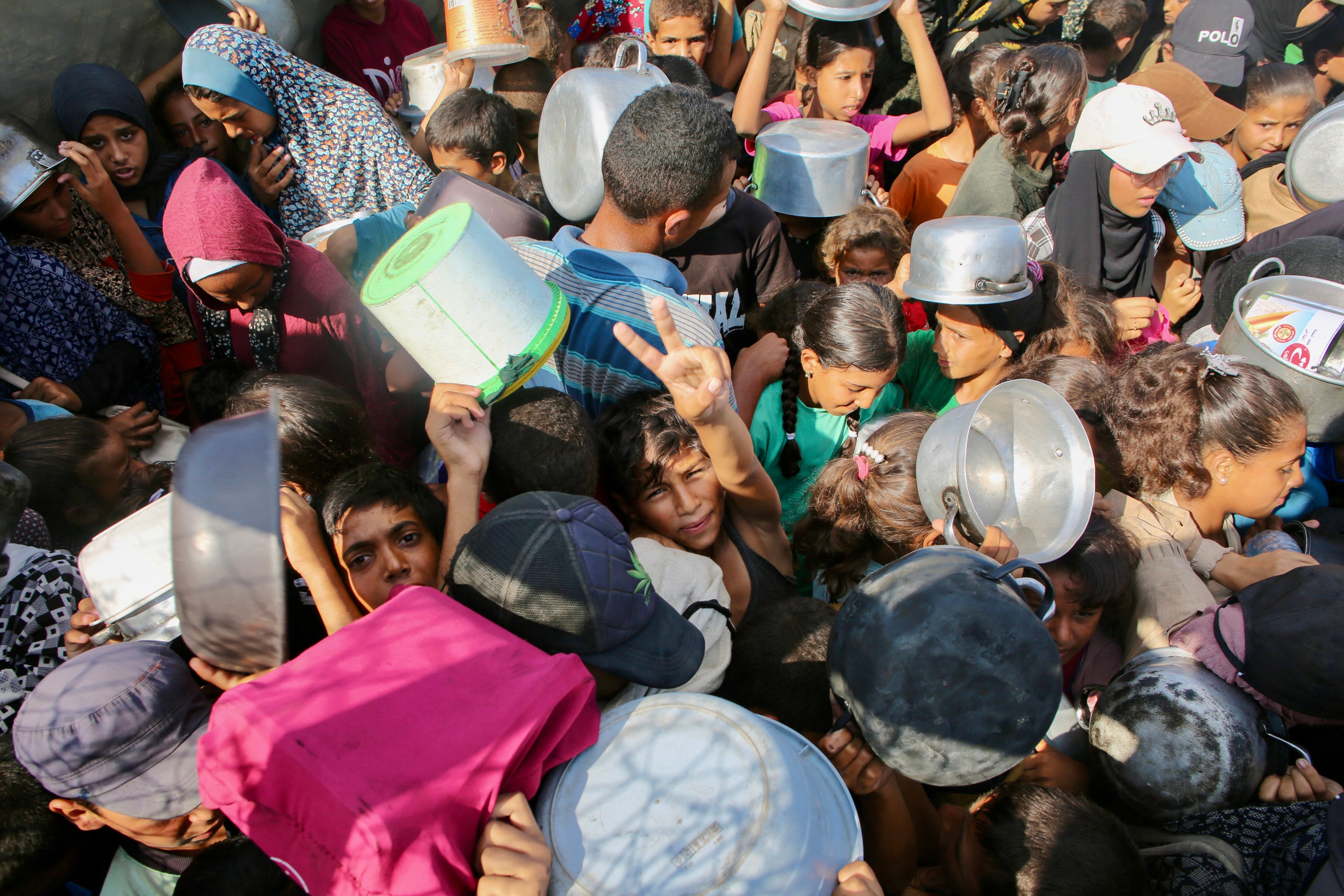 ‘Every day in Gaza, survival is a form of resistance’: starving Palestinians wait for a meal provided by a charity kitchen