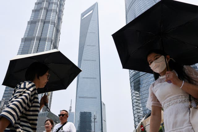 <p>People walk near Shanghai World Financial Centre in Shanghai</p>