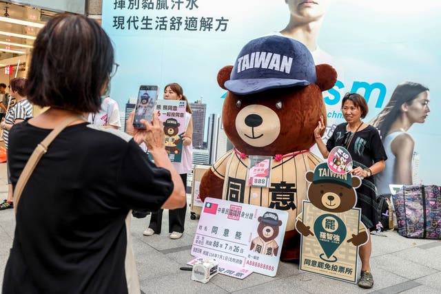 <p>A supporter of the recall election takes pictures with a mascot in Taipei on 22 July, 2025, ahead of the recall votes, which will be held on 26 July  </p>