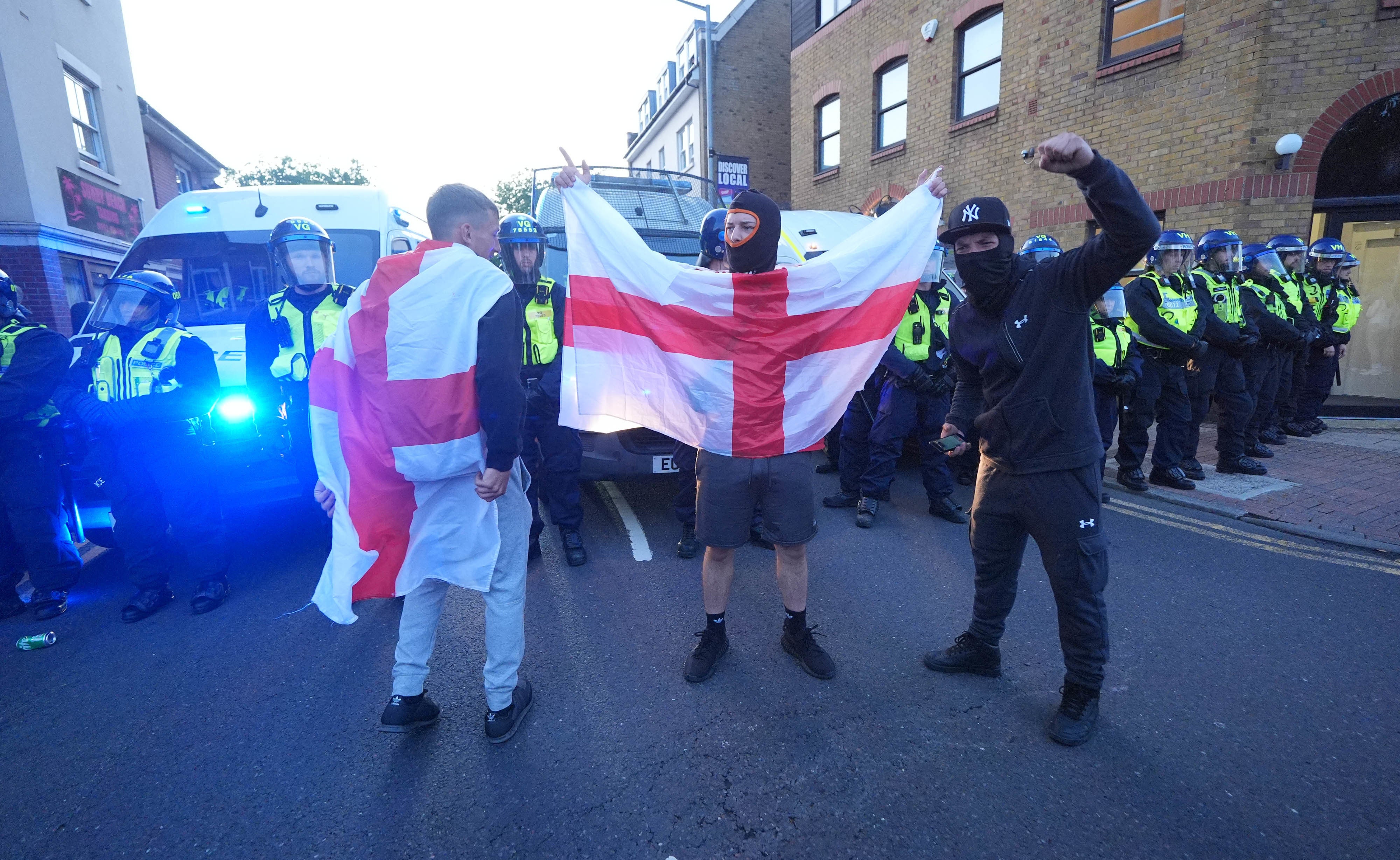 Protesters caught St. George's flag after a protest in Epping (Yui Mok/ PA)