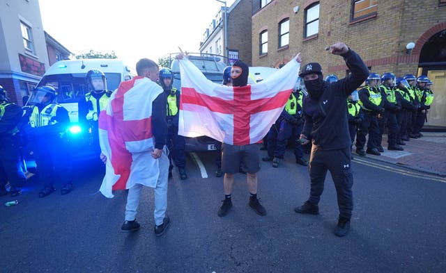 <p>Protesters hold up a flag of St George after a protest in Epping</p>